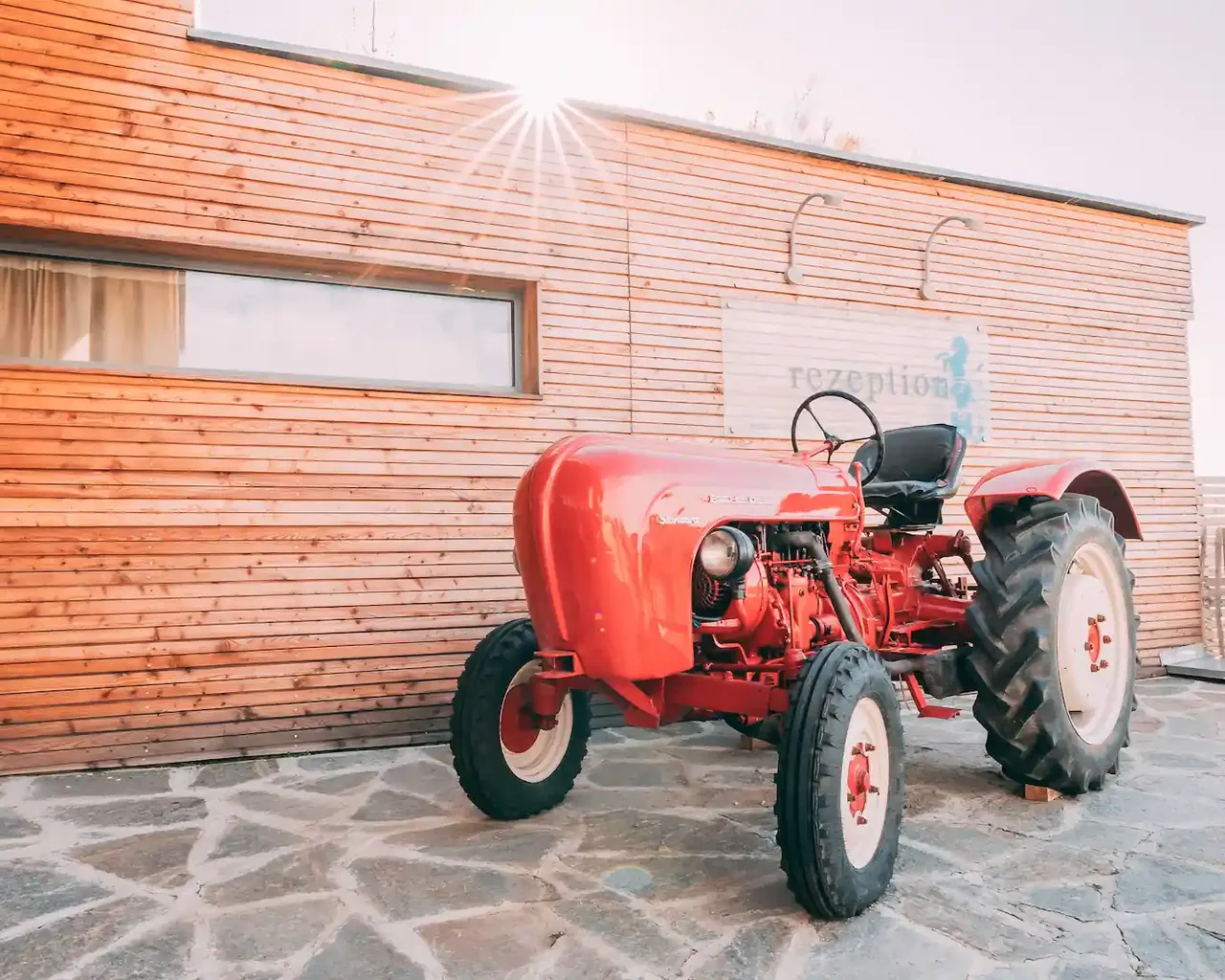 Tractor roșu în fața recepției Gut Hügle